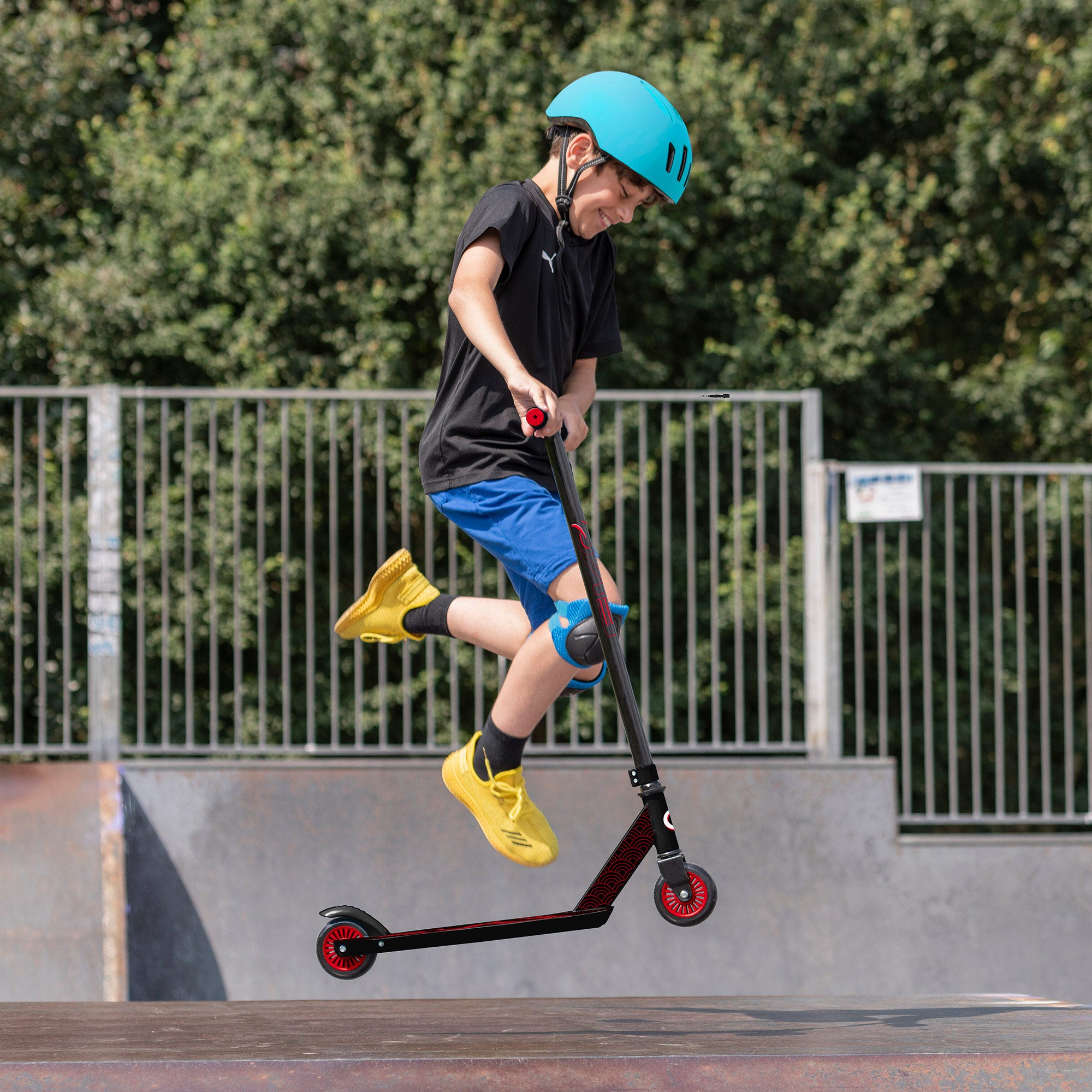 Trotinete infantil EVO com guiador giratório 360°, preto e vermelho.