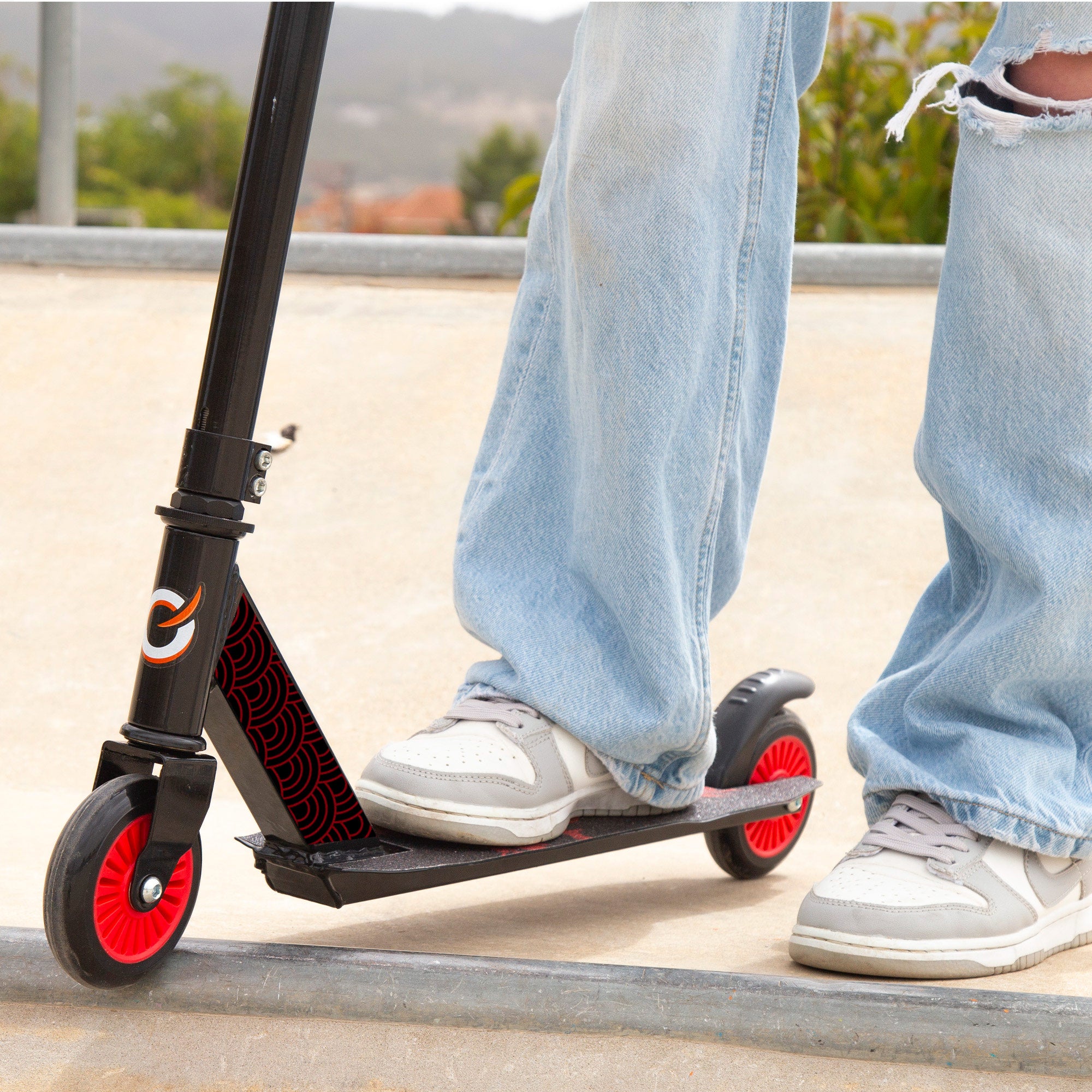 Trotinete infantil EVO com guiador giratório 360°, preto e vermelho.