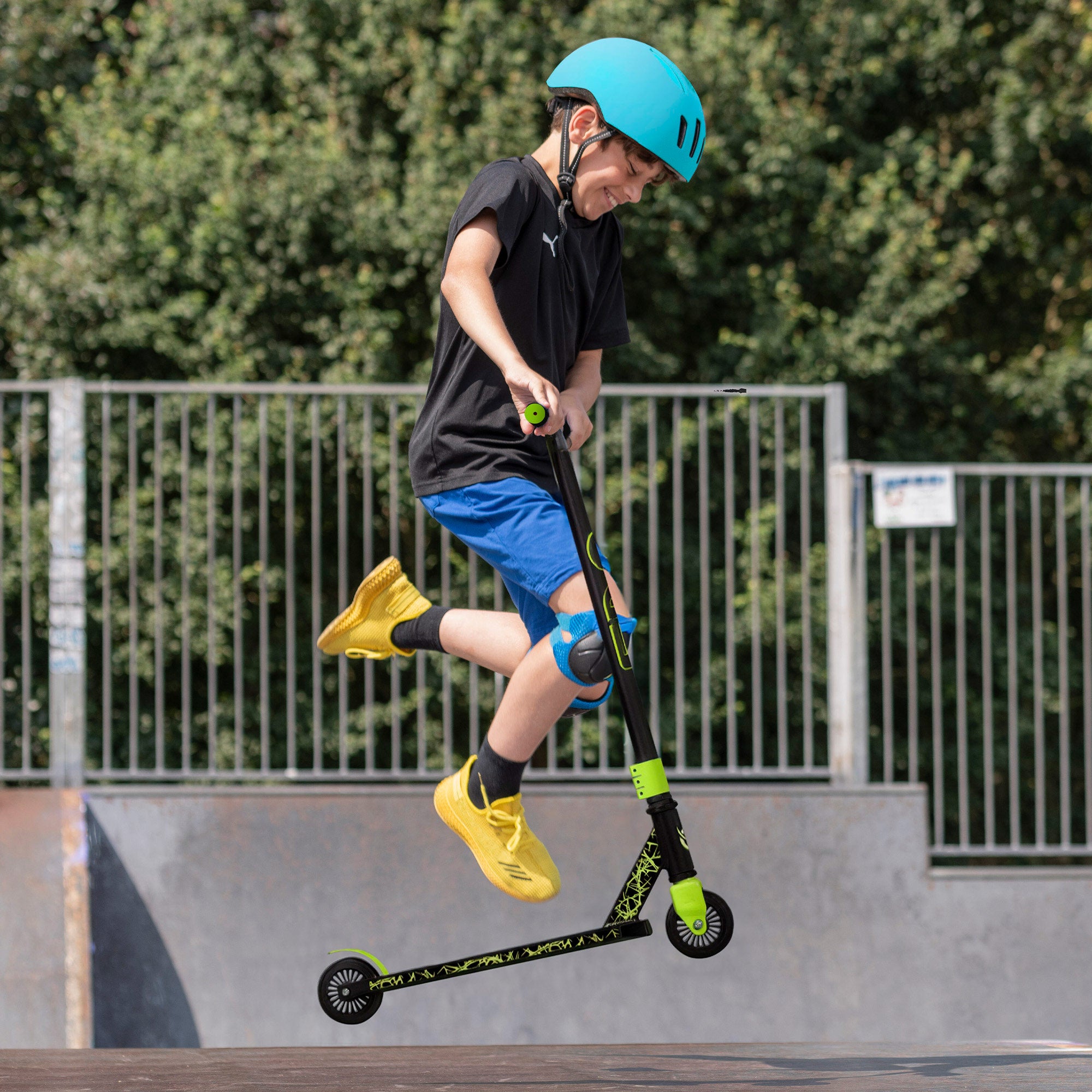 Trotinete infantil EVO com guiador giratório 360º, preto e verde.