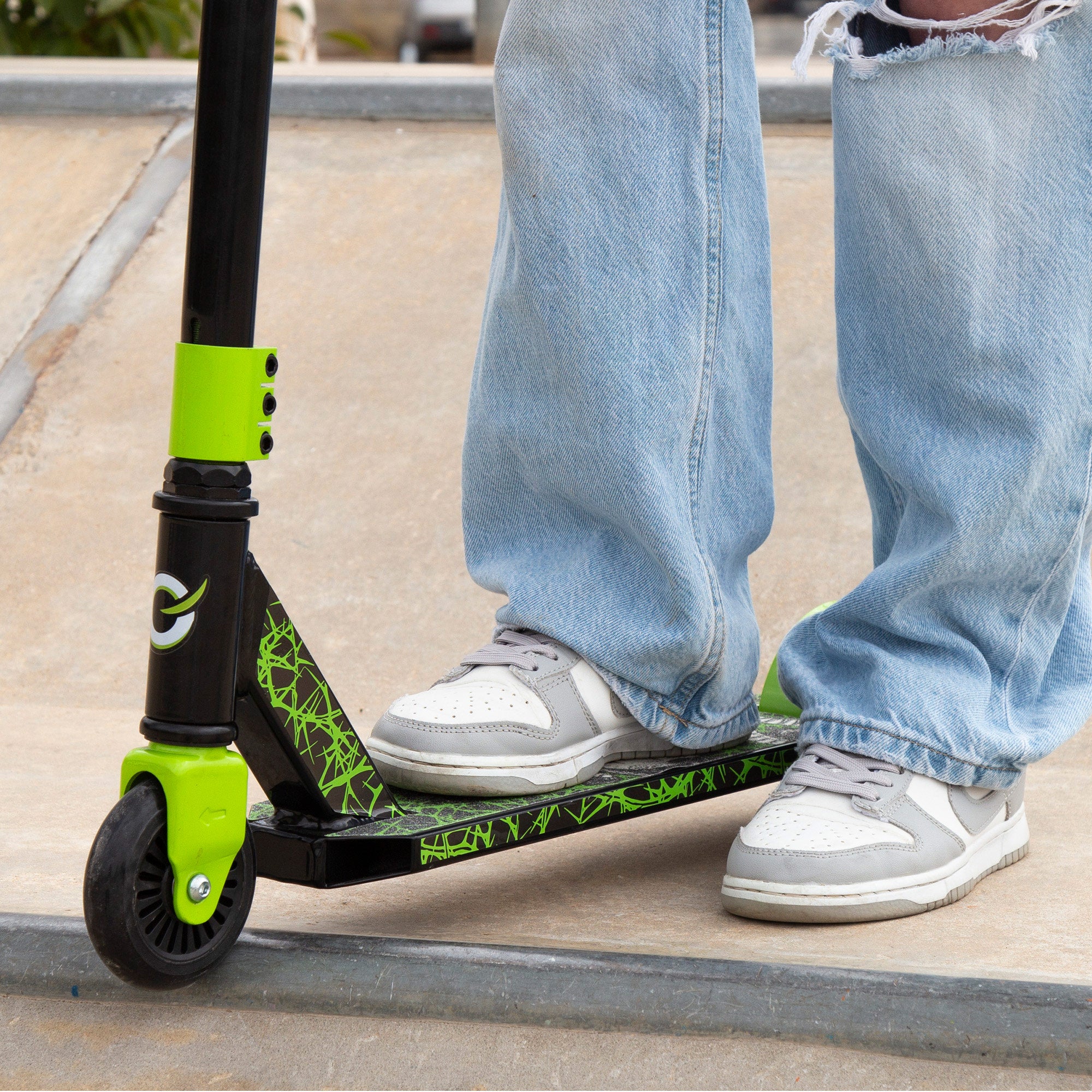 Trotinete infantil EVO com guiador giratório 360º, preto e verde.